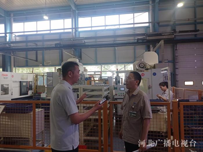 记者白雪峰采访企业铸造技术部经理徐贵强（右）