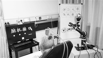 在浙江大学医学院附属第二医院，志愿者张大伯通过脑机接口控制机械臂写字。受访者供图