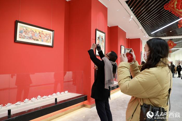 观众欣赏由西藏自治区延安精神研究会主办的“红色记忆”中国年画展。人民网记者 次仁罗布摄