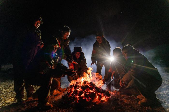 野生动物专业管护队员在宿营地的寒夜里烤火，燃料是野牦牛的粪便（5月10日摄）。新华社记者 丁增尼达 摄