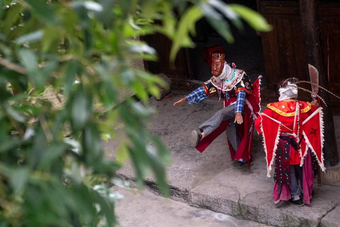 5月16日，在陈家老屋前的桂花树下，身着阳戏戏服的陈永霞（左）与戏搭子练习阳戏。