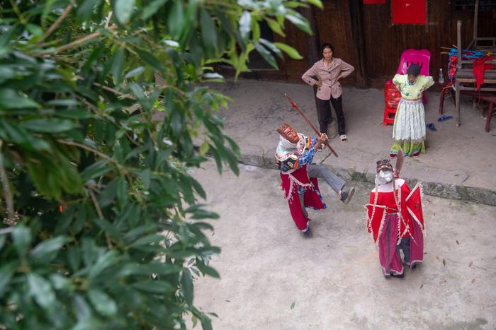 5月16日，在陈家老屋前的桂花树下，身着阳戏戏服的陈永霞（左一）与戏搭子练习。