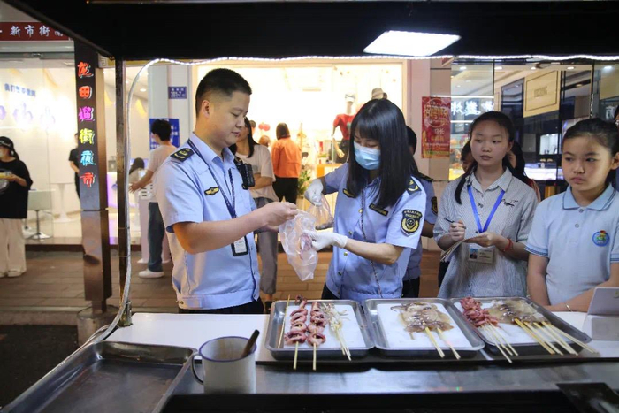 市场监管人员对夜市经营的食品进行抽查检测。