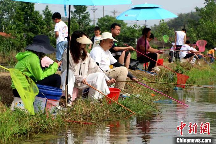 游客们围坐在水塘周围“比拼”钓虾。李海涛 摄