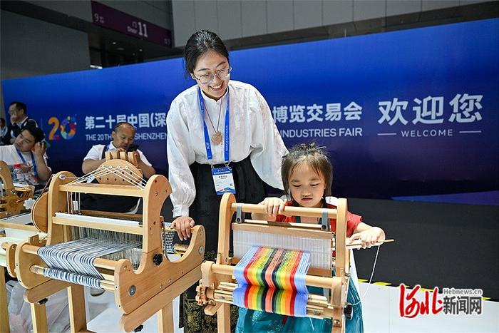 5月23日，第二十届中国（深圳）国际文化产业博览交易会河北展区，小游客正在体验织布机。 河北日报记者 赵 杰摄