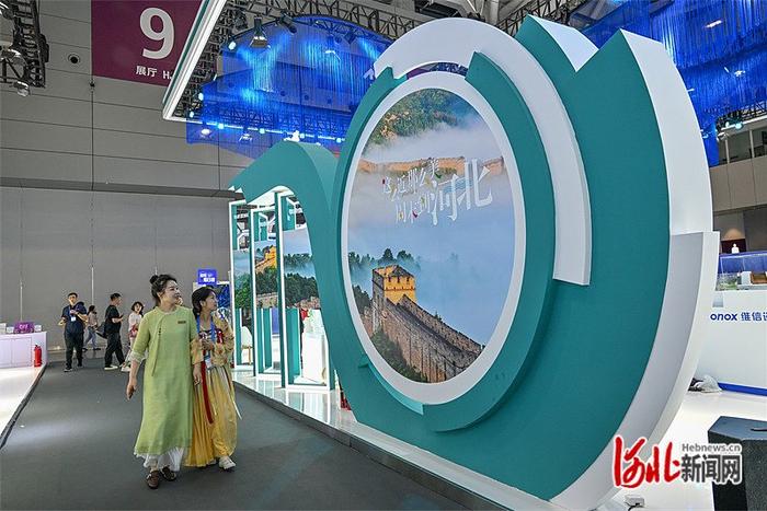 5月23日，第二十届中国（深圳）国际文化产业博览交易会河北展区，观众被墙上的大幅美景照片吸引。 河北日报记者 赵 杰摄