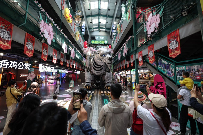 　　2024年5月22日，游客在辽宁省大连市熊洞街观看仿生机械巨熊表演。新华社记者 潘昱龙 摄