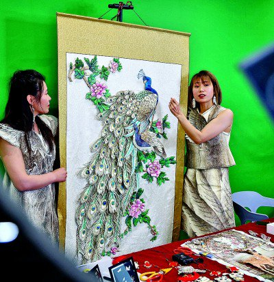     同江市非遗就业工坊的“绣娘”在直播中介绍鱼皮刺绣作品《花开富贵》。本报记者 刘宇航摄