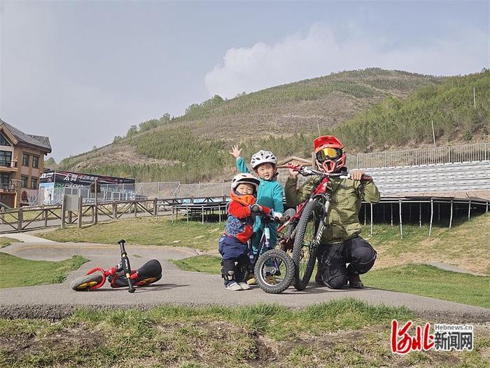 5月16日，奥运萌娃贝贝（中）和爸爸、弟弟在崇礼太舞小镇一起骑自行车。 河北日报记者 史晓多摄