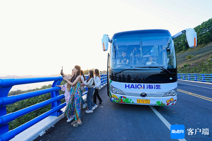 游客乘坐海南环岛旅游公路观光巴士打卡拍照。海汽集团供图