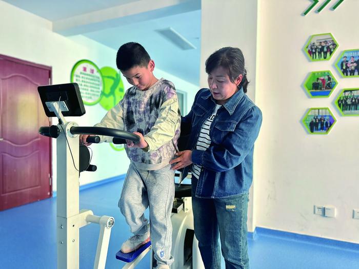 陈志芳帮助孤独症儿童做肢体协调训练。王晶 摄