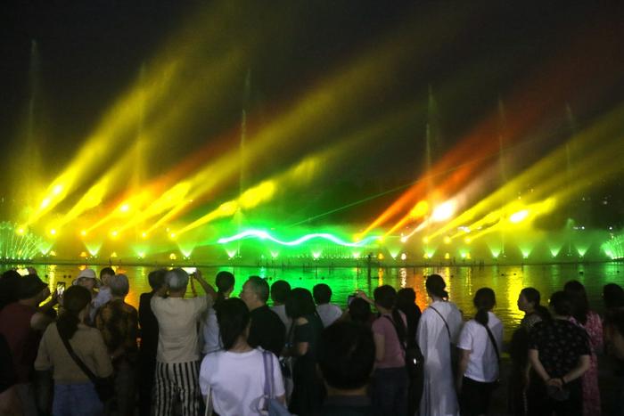 5月21日晚，游客在甘肃省敦煌市党河风情线观看大型水舞灯光秀《诗梦敦煌》