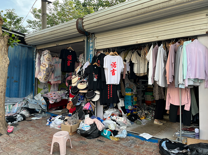 ▲ 王冠店门前，没有卖完的纪念衫。图 / 每日人物摄