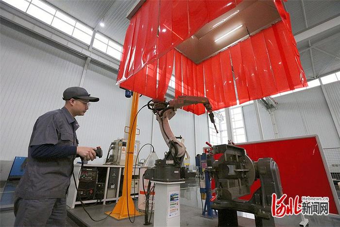 近日，在唐山百川机器人共享工厂，工作人员正调试机器人焊接工作站。 河北日报记者 王育民摄