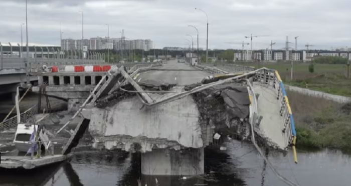 ▲在这座被炸毁的桥梁远处，可以看到正在建设中的新公寓楼（右）以及塔式起重机