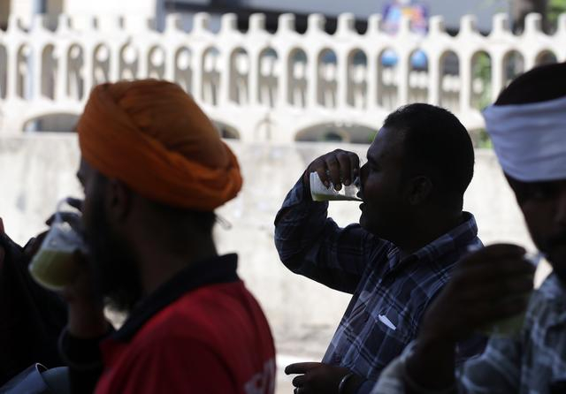 　　5月27日，在印度北部旁遮普邦阿姆利则地区，人们在炎热的午后喝路边售卖的甘蔗汁来消暑。新华社发（斯特林格摄）