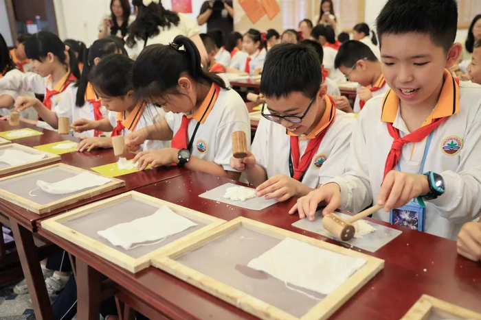 亲子家庭与民族路小学的师生代表在世界读书日活动中体验古代纸张制造技术