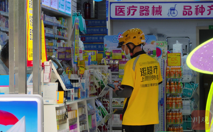 一名外卖员来到药店为线上买药的消费者取药。