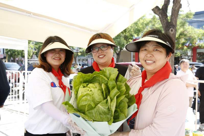 活动现场，三位女士手捧蔬菜花束。平谷区委宣传部供图