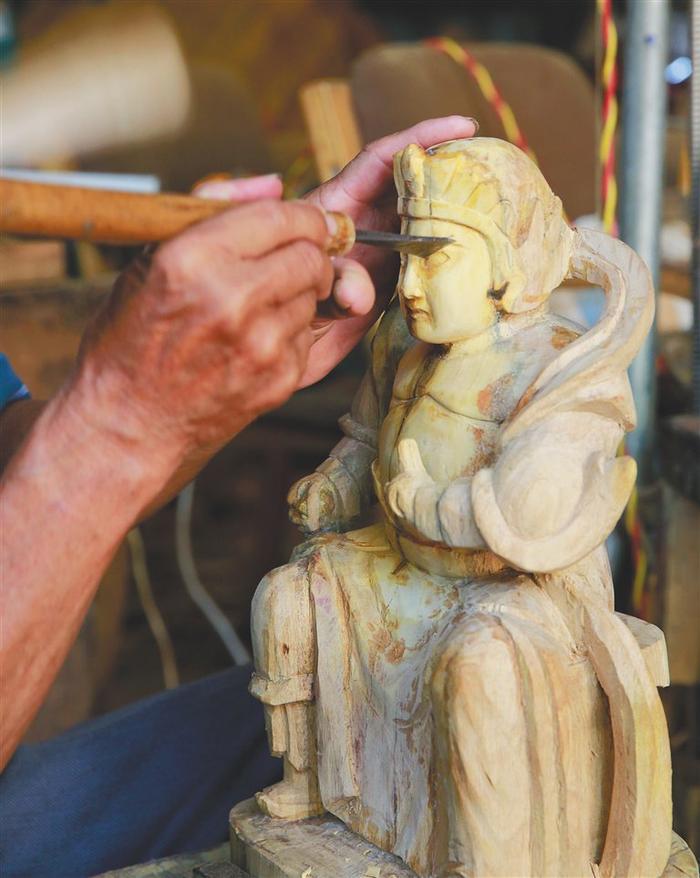 海南一位工匠创作木雕。