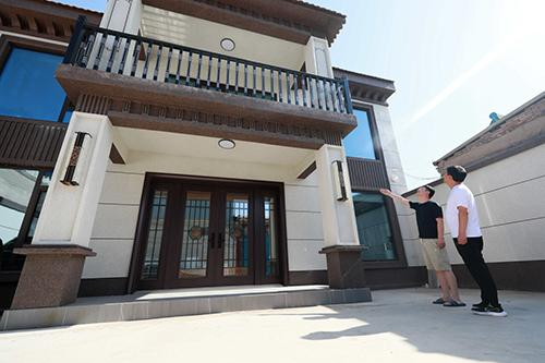     5月30日，任泽区南章固村村民杨智恒（左）为村民介绍自家装配式农房。  河北日报通讯员宋杰摄