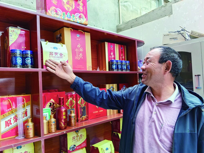 吕有金向顾客介绍自己的酩馏酒品牌。谢梦茹 摄