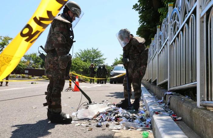 6月1日，韩国仁川，身穿防护服的士兵们清理一些从气球上摔落下来的垃圾。图/视觉中国