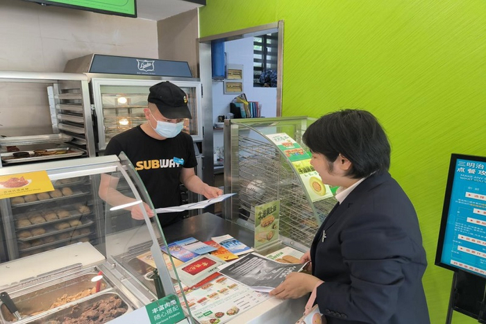 图为工行新城支行反诈宣讲员为一家快餐店店员宣讲反诈知识