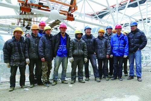 索网合龙时，南仁东（左七）、姜鹏（右一）与现场工人合影留念。受访者供图