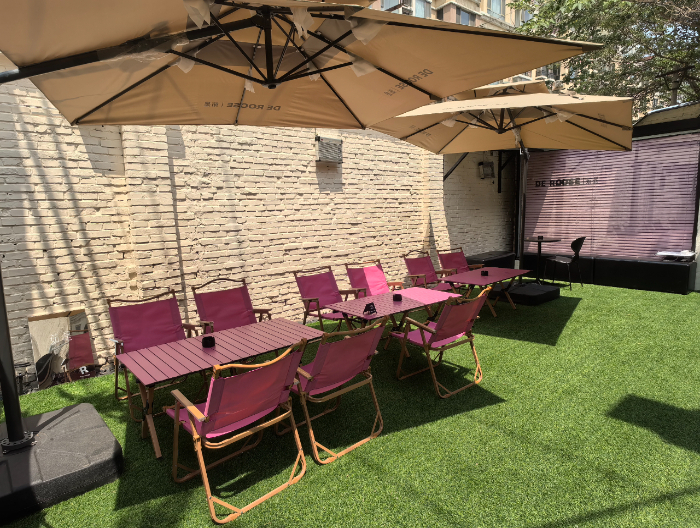 在茹是穿搭空间的服装区旁，设有人造草坪、遮阳伞和用餐区。