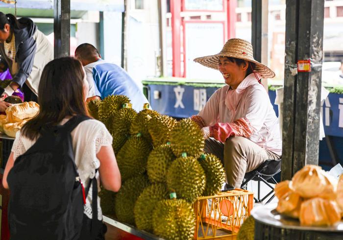  2023年5月18日，越南果商在广西东兴售卖榴莲。新华社记者胡星宇摄