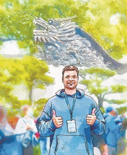 俄罗斯游客阿特米与豫园龙墙合影。 本报记者李宝花 摄