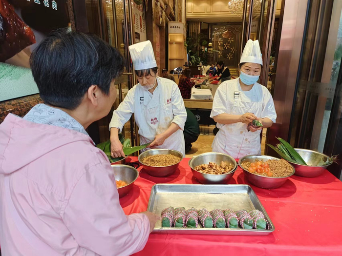 南京路上新雅粽娘正在包肉粽。劳动报记者陆燕婷 摄影