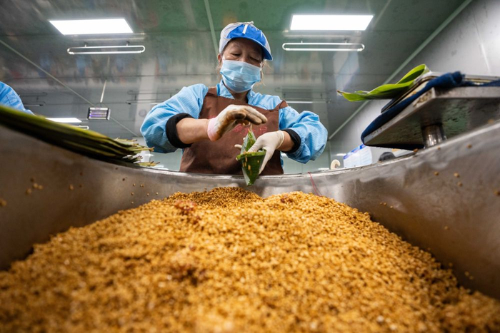 6月5日，在浏阳市关口街道道源湖村一家粽子生产车间，工人在包粽子。