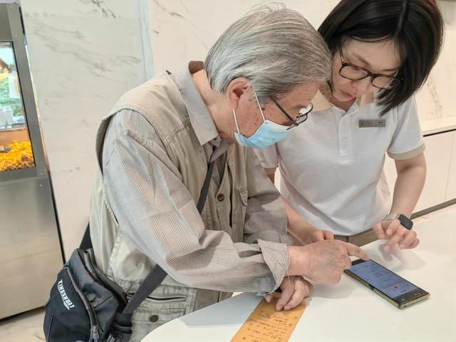 李长年在影城工作人员帮助下抢票。 钟菡 摄