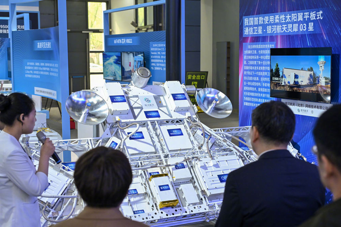 2024年4月26日，工作人员在中关村展示中心常设展上介绍柔性太阳翼平板式通讯卫星。新华社记者 李鑫 摄