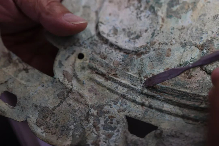 ▲6月3日，在三星堆文物保护和修复中心，“大国工匠”郭汉中正在修补一件青铜兽面文物的细小缝隙。