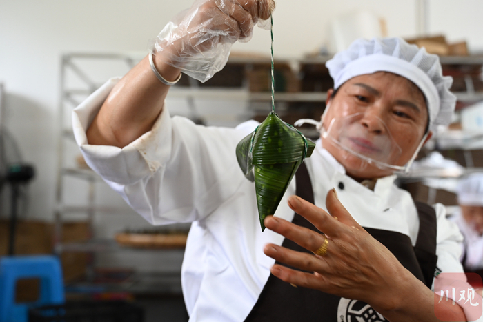 斗量村村民展示自己刚包好的粽子