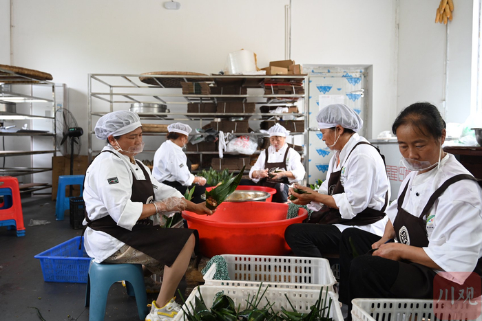 斗量村粽子加工坊内村民正在包粽子