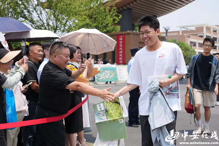2024高考地理科目考试结束，考生走出考场后，与加油人群击掌。