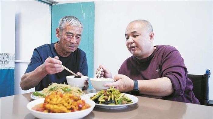 6月5日，张忠敏（左）与张建诚在家里一起吃晚饭。兵团日报全媒体记者 陈洋 摄