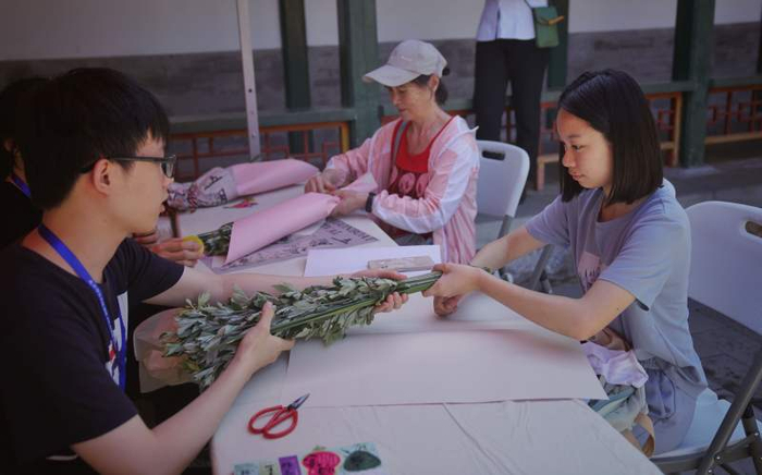 6月9日，香山公园，游客在致远斋“手作小广场”亲手制作艾草花束。新京报记者 薛珺 摄