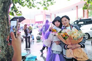 　　▲图为6月9日，考生走出乌当中学考点后手捧鲜花合影。 　　贵阳日报融媒体记者 周永 摄