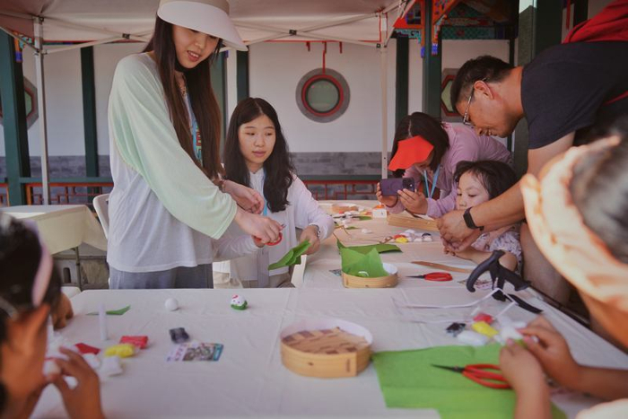 6月9日，香山公园，小朋友在科普老师的指导下现场制作黏土粽子。新京报记者 薛珺 摄