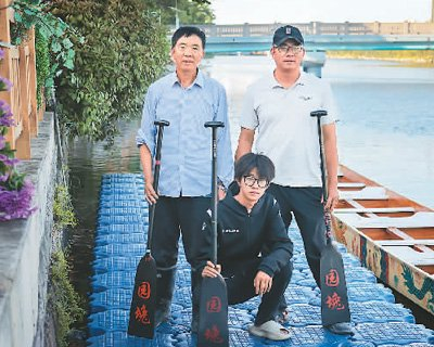 李维国（右）与父亲、儿子在沿山干河的龙舟码头。杨 亮摄