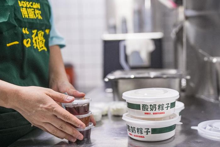 在乌鲁木齐，博斯坎酸奶粽子门店的工作人员在为顾客打包酸奶粽子。