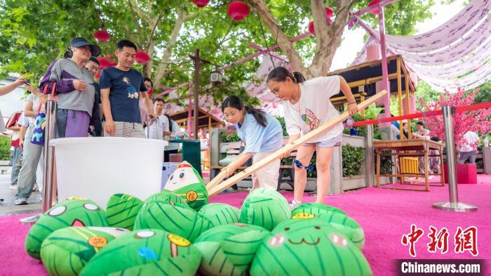 游客端午假期在郑州方特旅游度假区体验趣味夹粽子活动。张德坤 摄