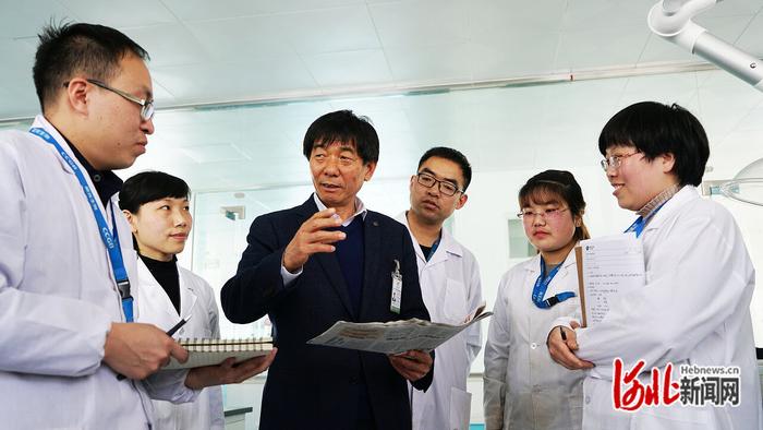 近日，卢庆国（左三）与晨光生物科研人员讨论生产技术。 河北日报通讯员 李卫国摄