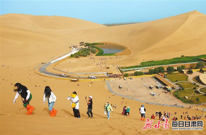 游客在敦煌鸣沙山月牙泉景区游玩。新甘肃·甘肃日报通讯员 张晓亮