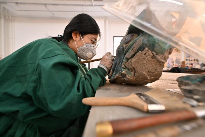 2月26日，在云冈研究院可移动文物修复室，工作人员正在进行除尘作业。（新华社记者 詹彦 摄）